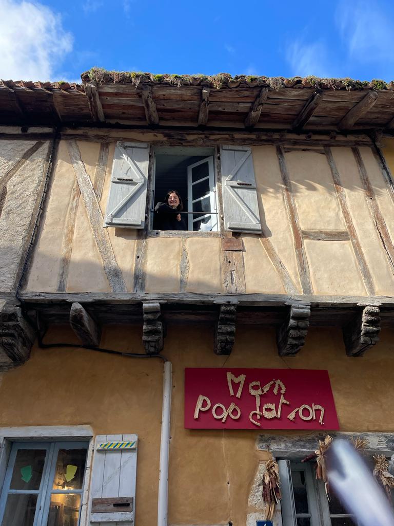 Juliette, en service civique à Sarrant est à la fenêtre de la maison où elle loge et travaille 