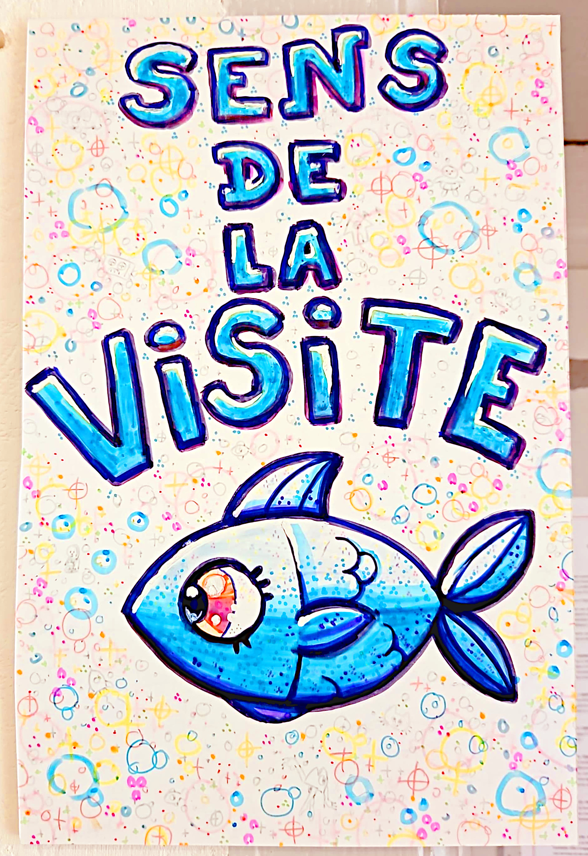Un panneau "sens de la visite" avec un poisson bleu dessiné