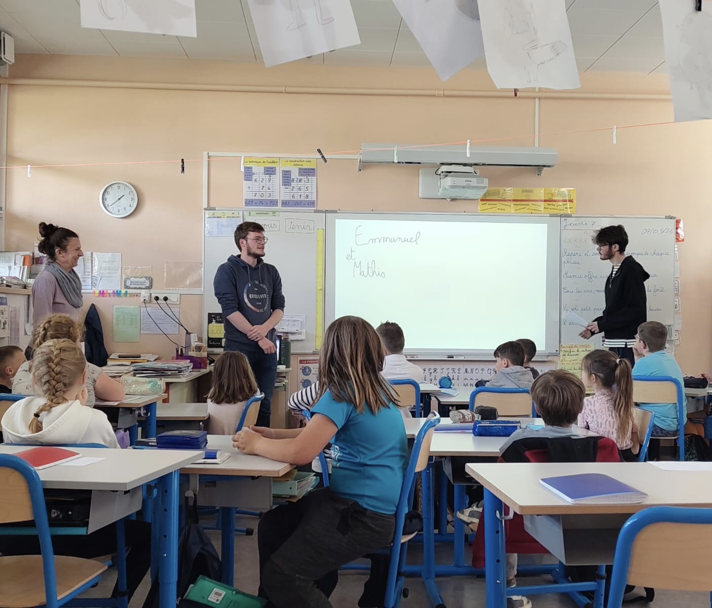 Emmanuel et Mathis lisent un conte autour de l'amnésie environnementale aux élèves de l'école Raymond Queneau